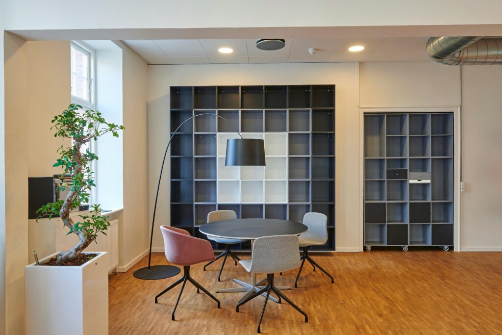 Bright and stylish office space with contemporary furniture and open shelving.